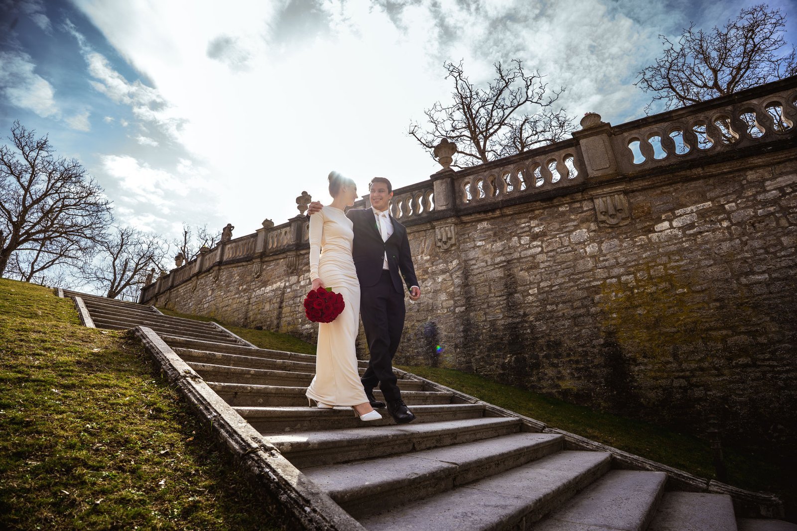 Hochzeitsfoto vom Hochzeitspaar umarmen sich und laufen eine Treppe runter