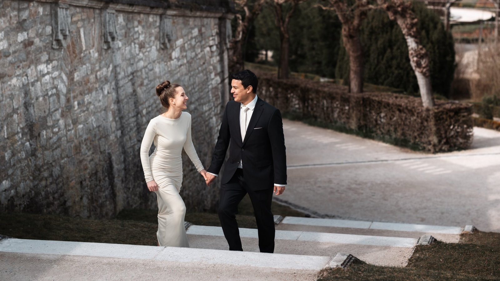 Hochzeitsfoto vom Hochzeitspaar, haltet sich an den Händen und läuft eine Treppe hoch